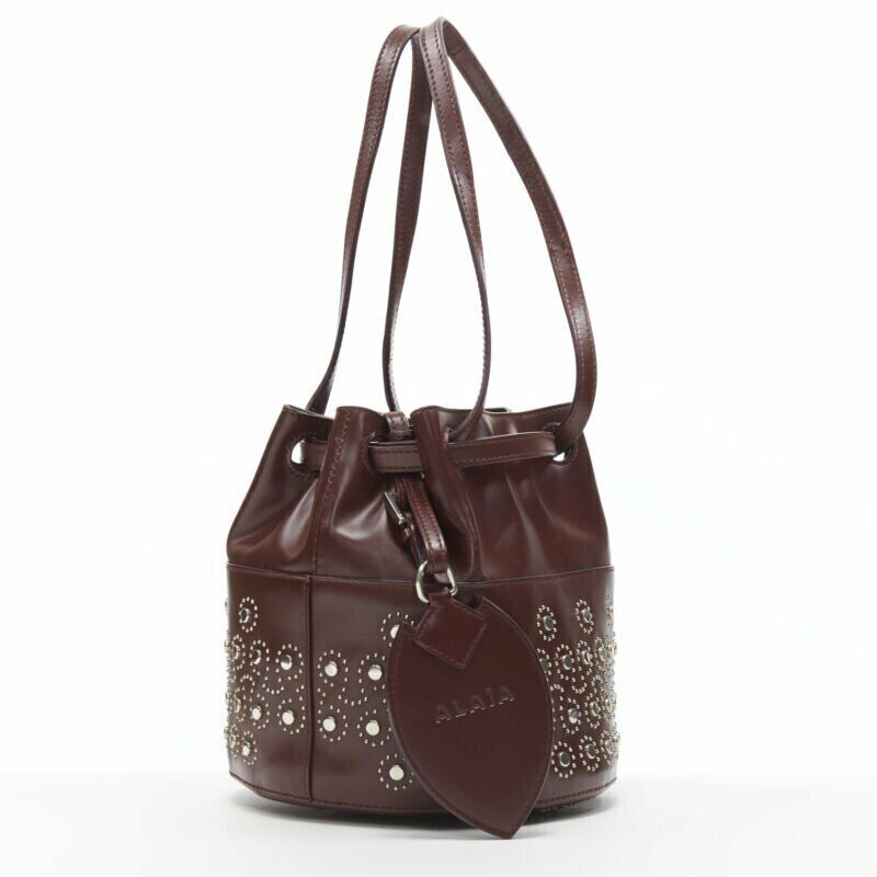 ALAIA burgundy red geometric silver studded drawstring mirror charm bucket bag