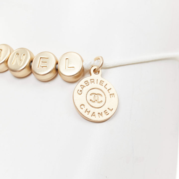 CHANEL white gold tone logo letter bead charm white thread lucky bracelet