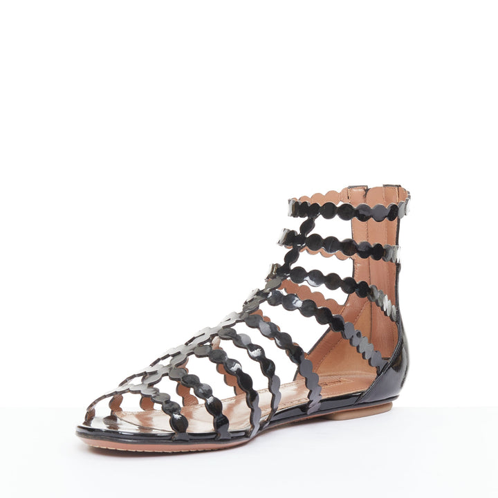ALAIA black patent leather laser cut scalloped cage gladiator flat sandals EU36