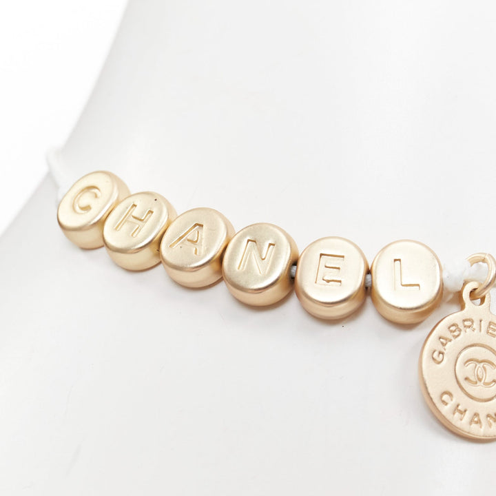 CHANEL white gold tone logo letter bead charm white thread lucky bracelet