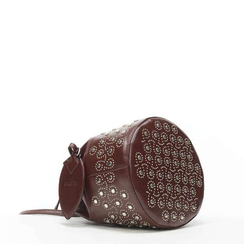 ALAIA burgundy red geometric silver studded drawstring mirror charm bucket bag